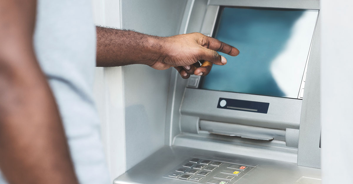 Man uses an ATM to withdraw cash.