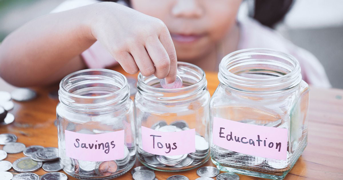 child putting a coin into a jar labeled toys