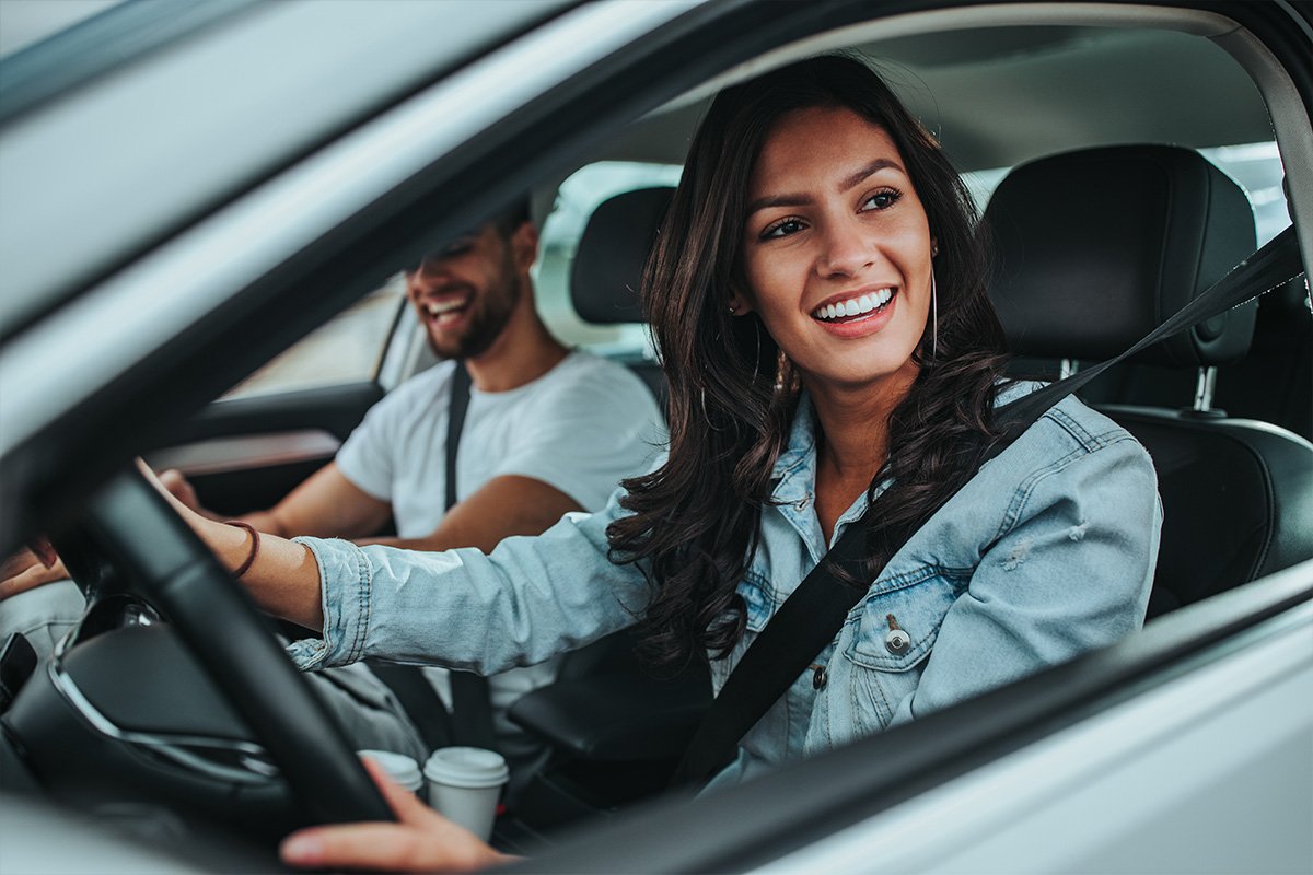 woman in a drivers seat while smiling