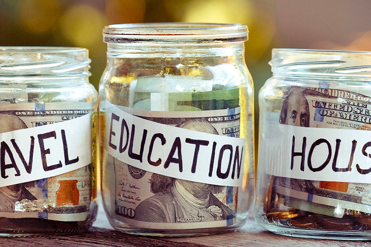 Jars of money labeled travel, education and house.