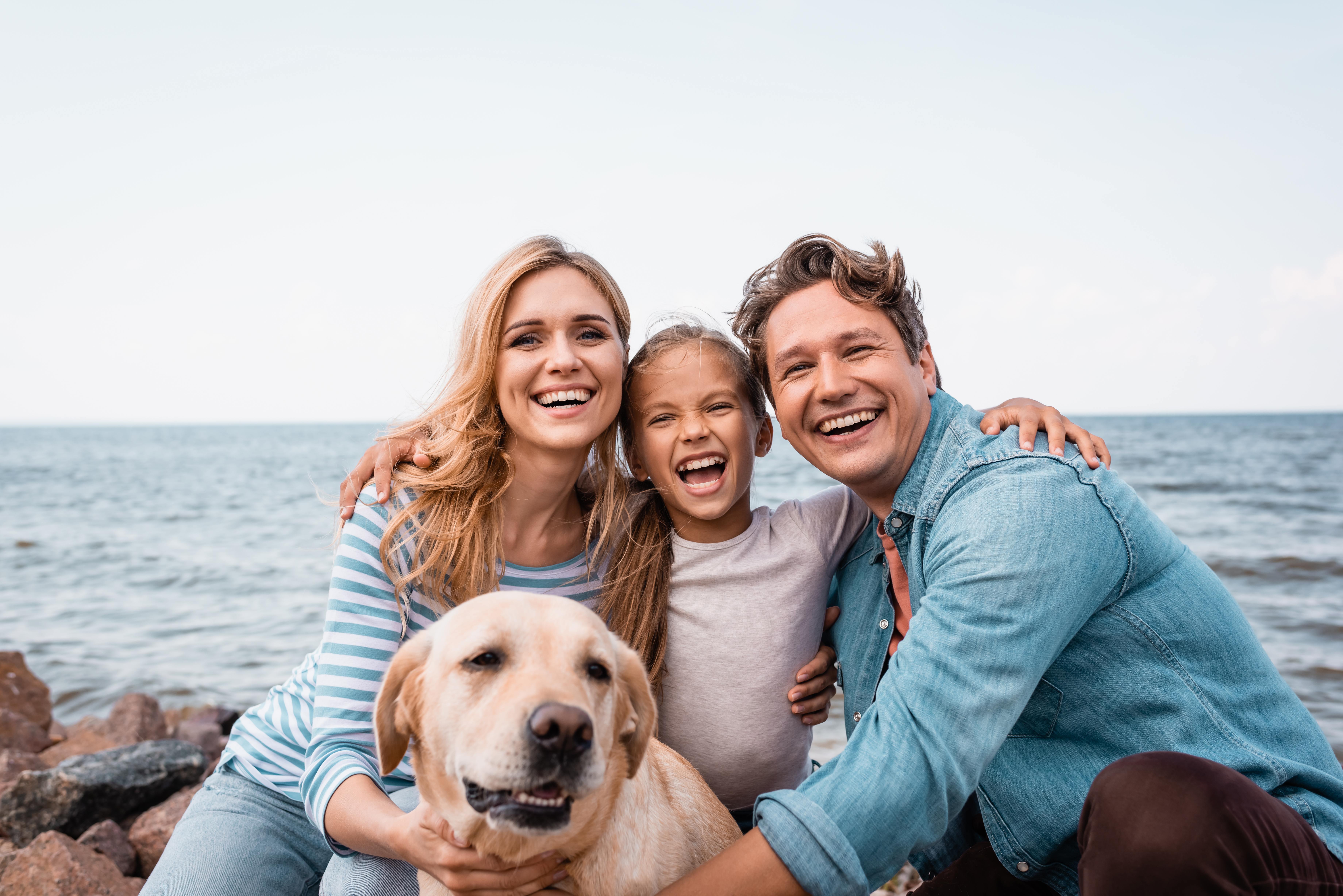 Happy family with a dog enjoying a vacation at the beach.