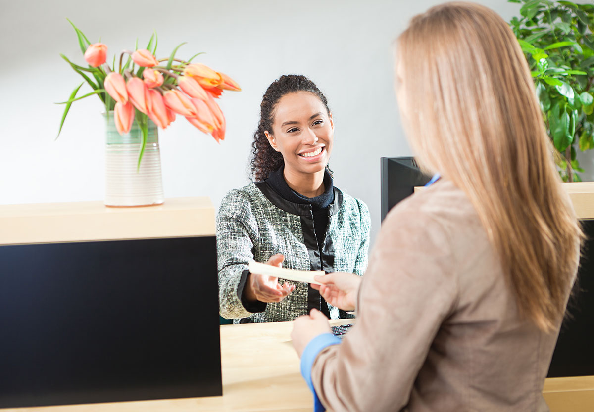Young Woman and Teller Complete Transaction