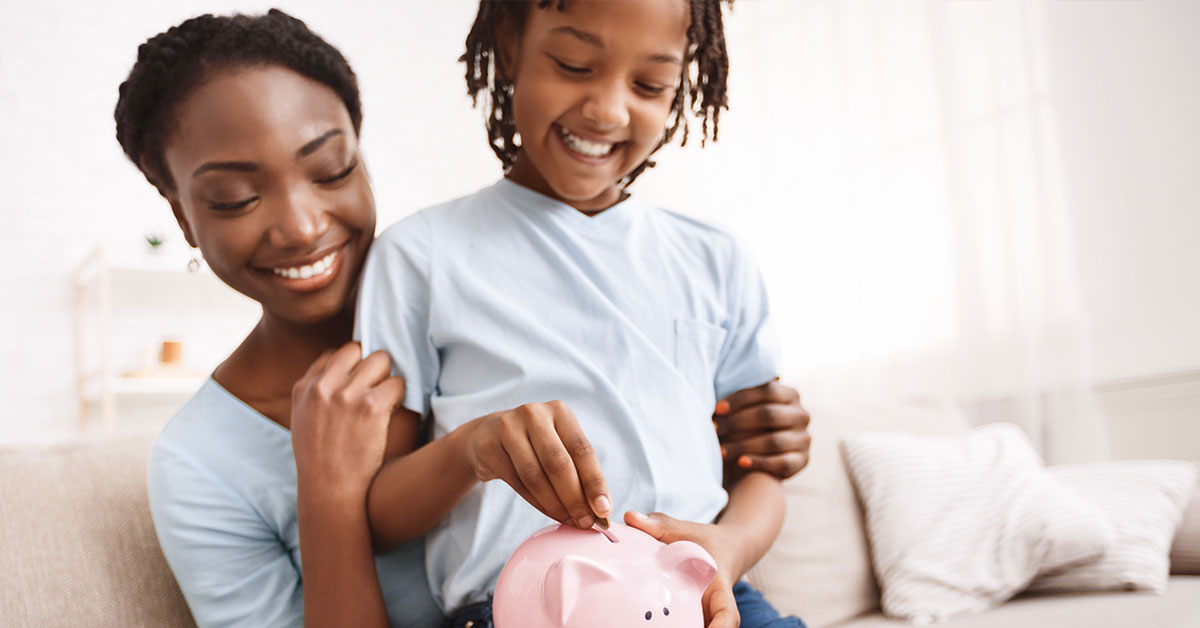 Mom and child placing coins in a piggy bank